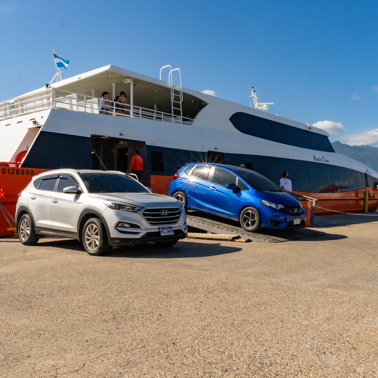 Vehicles and passengers boarding the Roatán Dream ferry